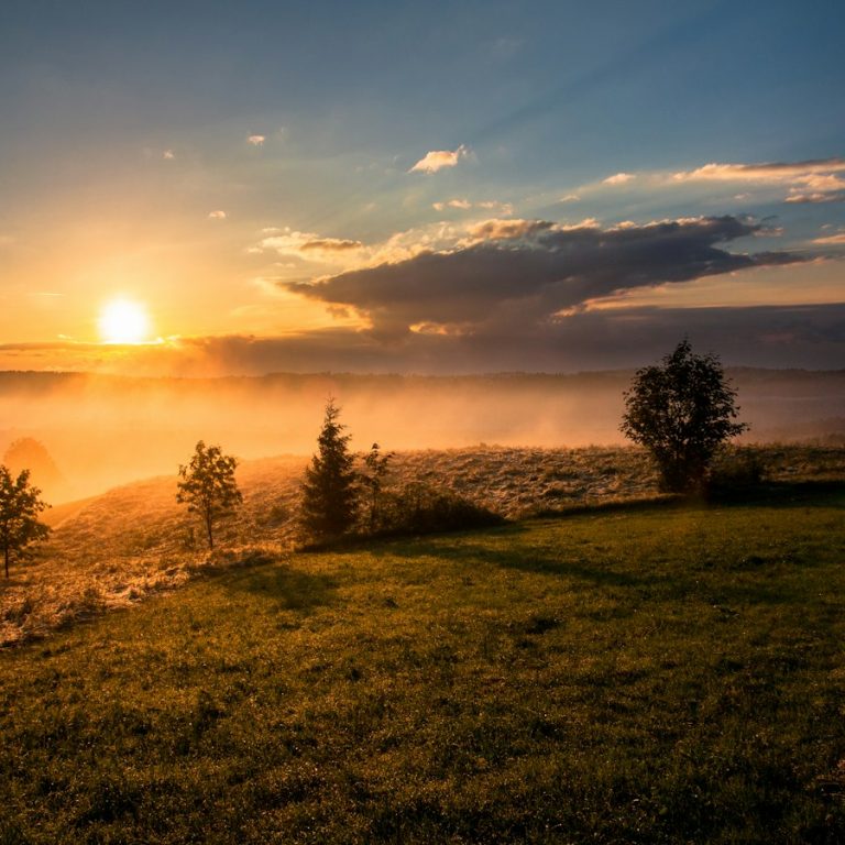 Soleil levant sur des collines brumeuses